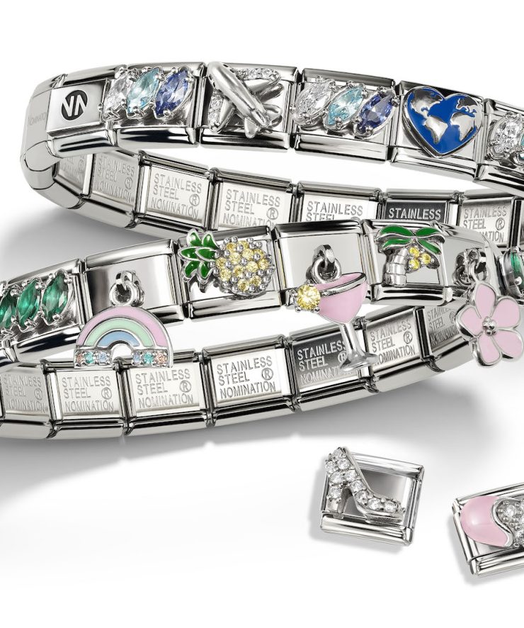 Zwei Composable Armbänder aus Edelstahl mit bunten Charms wie Regenbogen, Ananas, Blume, Cocktailglas, Herz, Flugzeug und Weltkugel. Ergänzt durch einzelne Schmuckelemente in Form eines Schuhs und einer Handtasche.