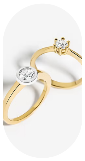 Zwei elegante Ringe aus Gelbgold mit funkelnden Solitär-Diamanten in unterschiedlichen Fassungen. Das zeitlose Design vereint klassische Eleganz mit moderner Leichtigkeit und eignet sich ideal als Verlobungsring oder stilvolles Schmuckstück für jeden Tag.