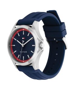 Analog-Armbanduhr von Tommy Hilfiger mit silberfarbenem Edelstahlgehäuse, strukturiertem blauem Zifferblatt mit roter Minuteneinteilung, silbernen Zeigern und Stundenmarkierungen sowie einem blauen Silikonarmband, hier in schräger Seitenansicht dargestellt.