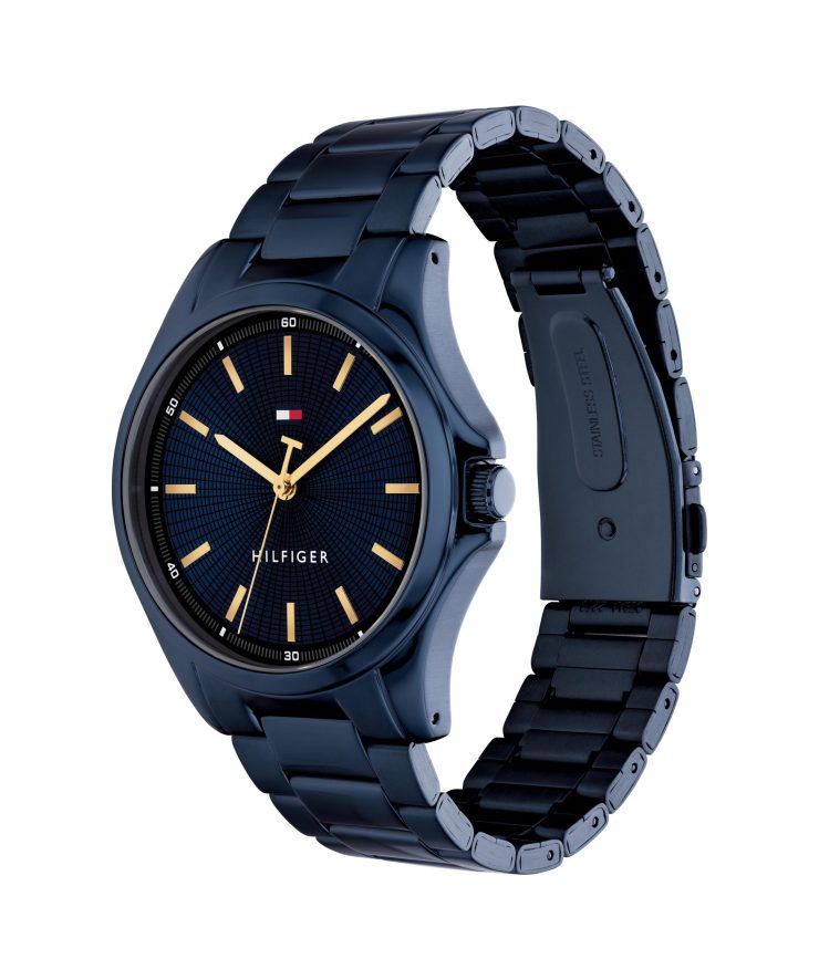 Tommy Hilfiger Armbanduhr mit blauem, strukturiertem Zifferblatt, goldfarbenen Stundenmarkierungen und Zeigern, blauem Edelstahlgehäuse und -armband sowie minimalistischem Dreizeiger-Design auf hellem Hintergrund