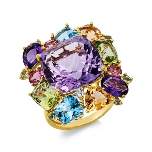 Auffälliger goldfarbener Statement-Ring mit großem violettem Schmuckstein im Zentrum, umgeben von facettierten Schmucksteinen in Blau, Grün, Rosa, Orange und Violett auf hellem Hintergrund