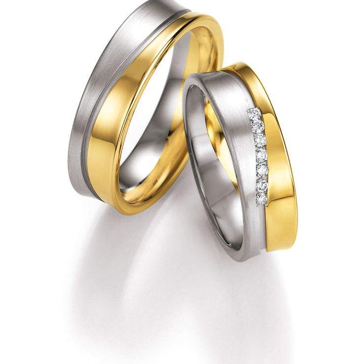 Elegantes Trauring-Set in edler Bicolor-Optik aus silberfarbenen und goldfarbenen Elementen. Die harmonische Kombination aus mattierten und polierten Oberflächen verleiht den Ringen eine moderne und zugleich zeitlose Ausstrahlung. Der Damenring wird durch eine funkelnde Reihe von Brillanten stilvoll hervorgehoben. Ein hochwertiges Symbol für Liebe, Zusammenhalt und lebenslange Verbundenheit.