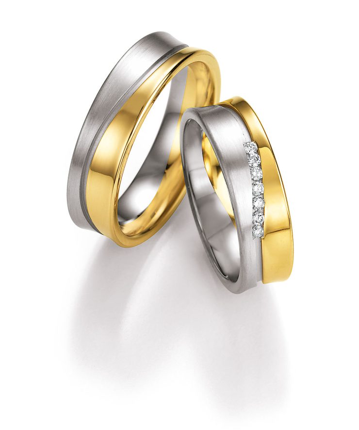 Elegantes Trauring-Set in edler Bicolor-Optik aus silberfarbenen und goldfarbenen Elementen. Die harmonische Kombination aus mattierten und polierten Oberflächen verleiht den Ringen eine moderne und zugleich zeitlose Ausstrahlung. Der Damenring wird durch eine funkelnde Reihe von Brillanten stilvoll hervorgehoben. Ein hochwertiges Symbol für Liebe, Zusammenhalt und lebenslange Verbundenheit.