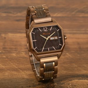 Waidzeit Armbanduhr mit bronzefarbenem achteckigem Gehäuse, dunklem Holzzifferblatt, Wochentags- und Datumsanzeige und passendem bronzefarbenen Metallarmband mit Holzeinlagen, präsentiert auf einer Holzoberfläche