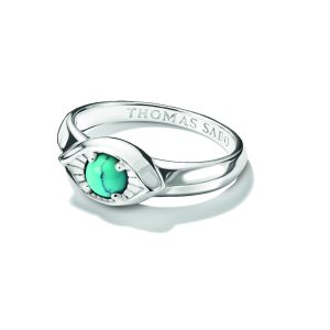 Eleganter Ring aus poliertem Silber mit einem ovalen, türkisfarbenen Schmuckstein als Blickfang. Das Auge-inspirierte Design mit feinen Strahlenstrukturen verleiht dem Schmuckstück eine symbolische und moderne Ausstrahlung. Die glänzende Ringschiene und der leuchtende Stein sorgen für einen stilvollen Kontrast und machen den Ring zu einem besonderen Accessoire, präsentiert auf hellem Hintergrund