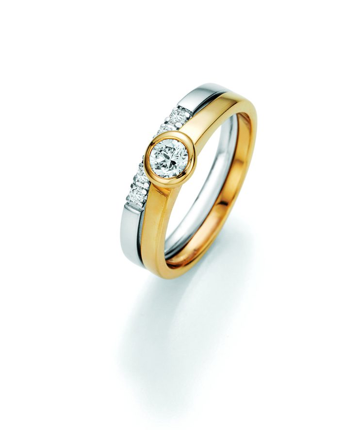 Eleganter Ring aus Gelb- und Weißgold mit zentral gefasstem Brillant und seitlichem Diamantbesatz