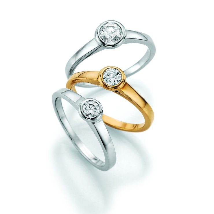 Zeitlose Solitärringe aus Weißgold und Gelbgold mit brillantgeschliffenem Diamanten in eleganter Zargenfassung. Das schlichte, moderne Design betont die Schönheit des Steins und macht die Ringe zu stilvollen Begleitern für Verlobung, Jubiläum oder besondere Momente.