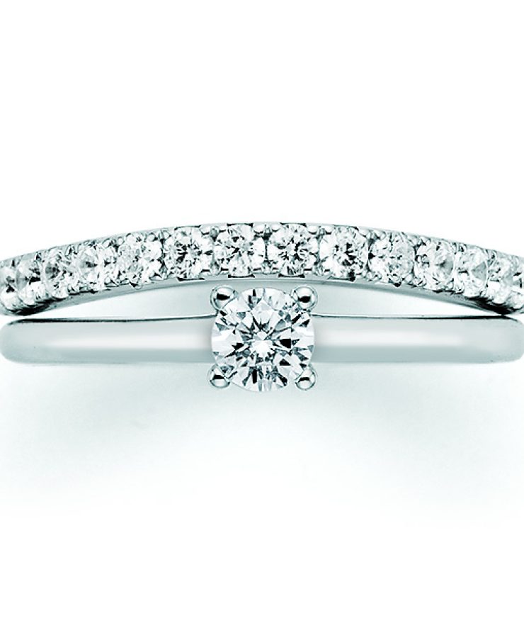 Eleganter Ring aus Weißgold mit zentralem Brillanten in Krappenfassung und funkelnder Pavé-Diamantschiene für einen zeitlosen und luxuriösen Auftritt